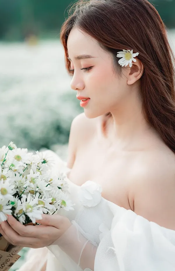 Beautiful blonde woman with flower wreath on her head. Beauty girl with flowers hairstyle. Girl in a summer forest. Fashion photo