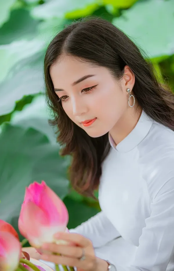 Beautiful blonde woman with flower wreath on her head. Beauty girl with flowers hairstyle. Girl in a summer forest. Fashion photo